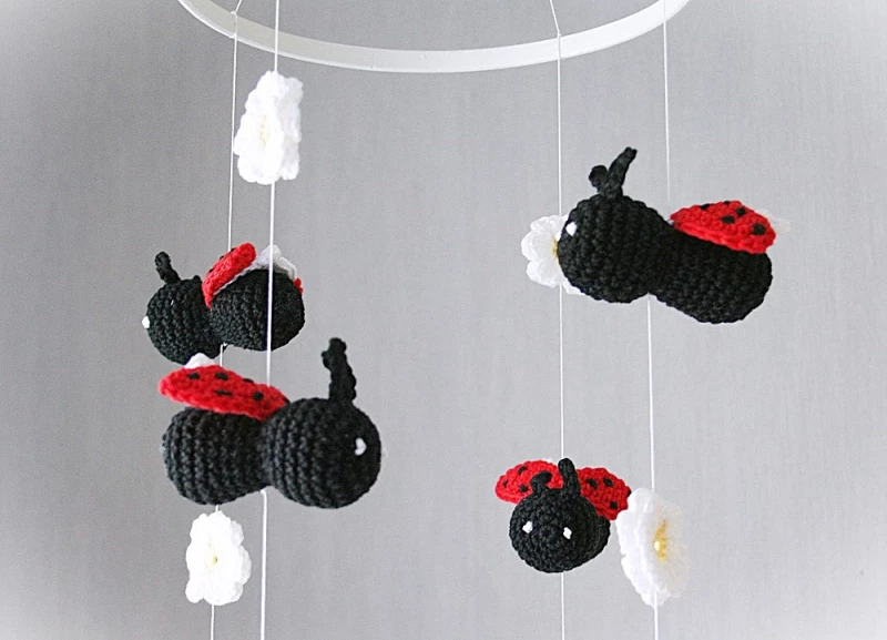 gehäkeltes Babymobile vier Marienkäfer  und viele Gänseblümchen