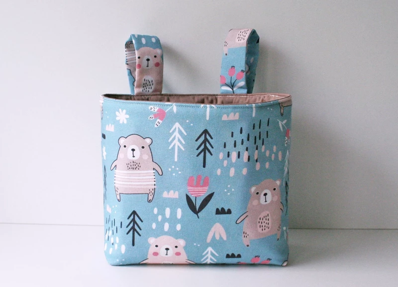 beige farbene Hängetasche mit schwarzen Outline Tieren